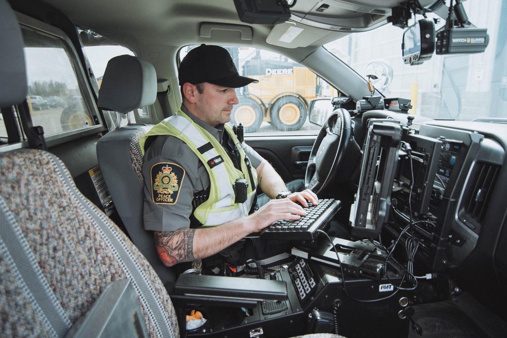 Community peace officer working on a mobile laptop inside a patrol vehicle